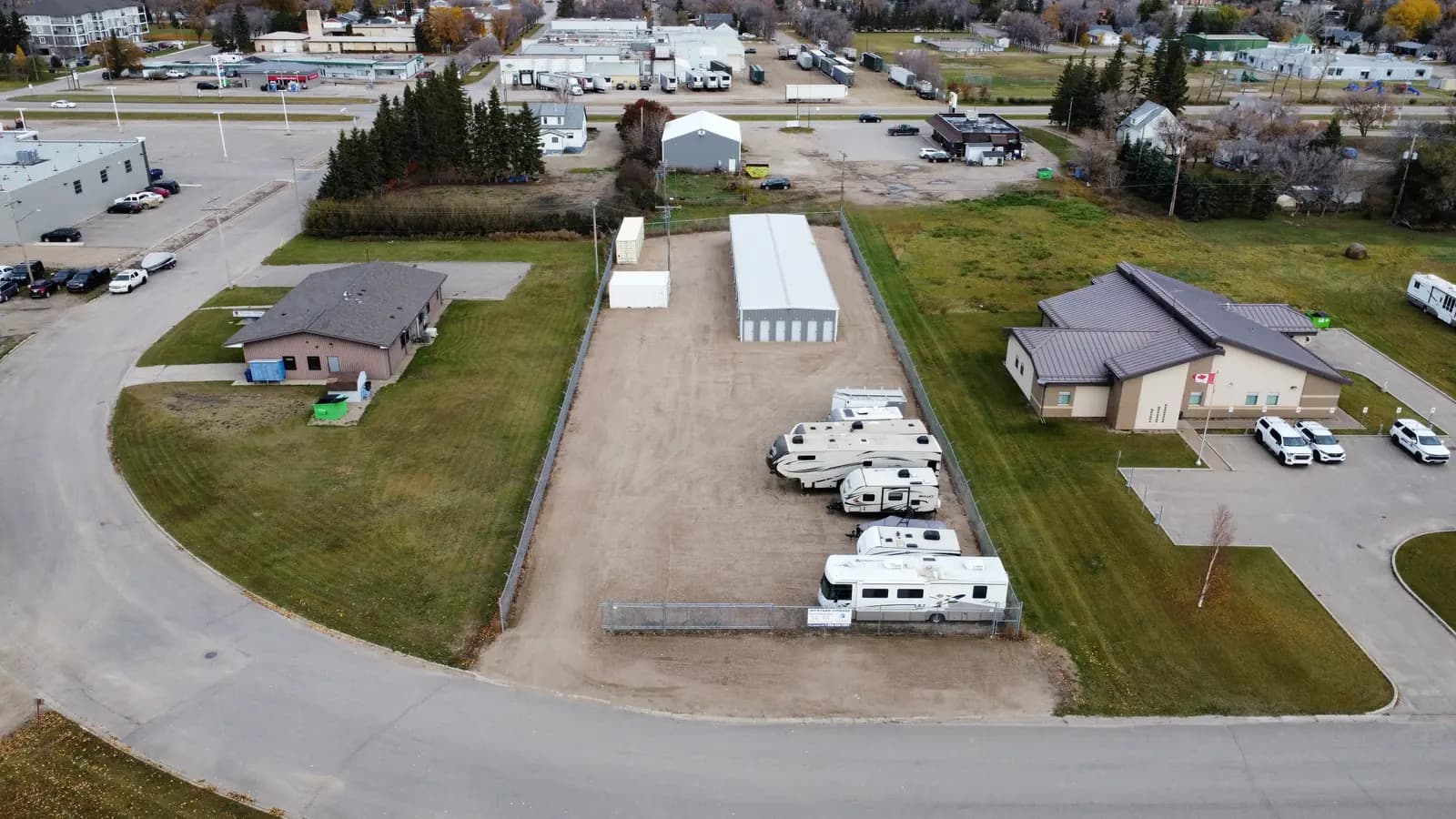 Fenced yard along the storage building, with RVs parked